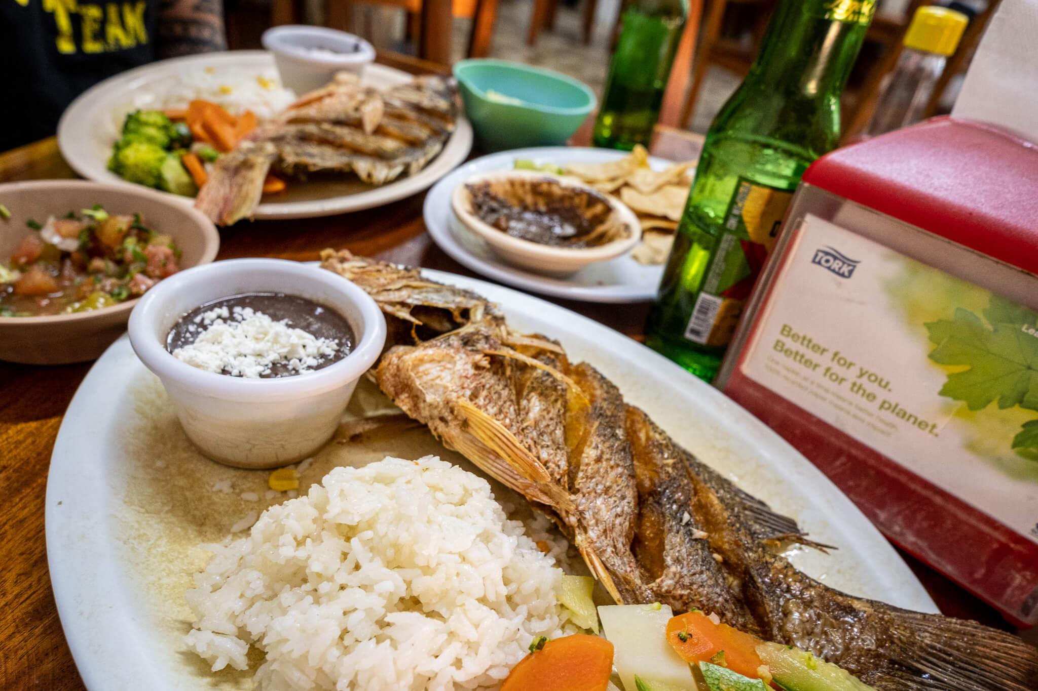 Plate with a fried whole fish, rice and refried beans at El Camello Jr in Tulum