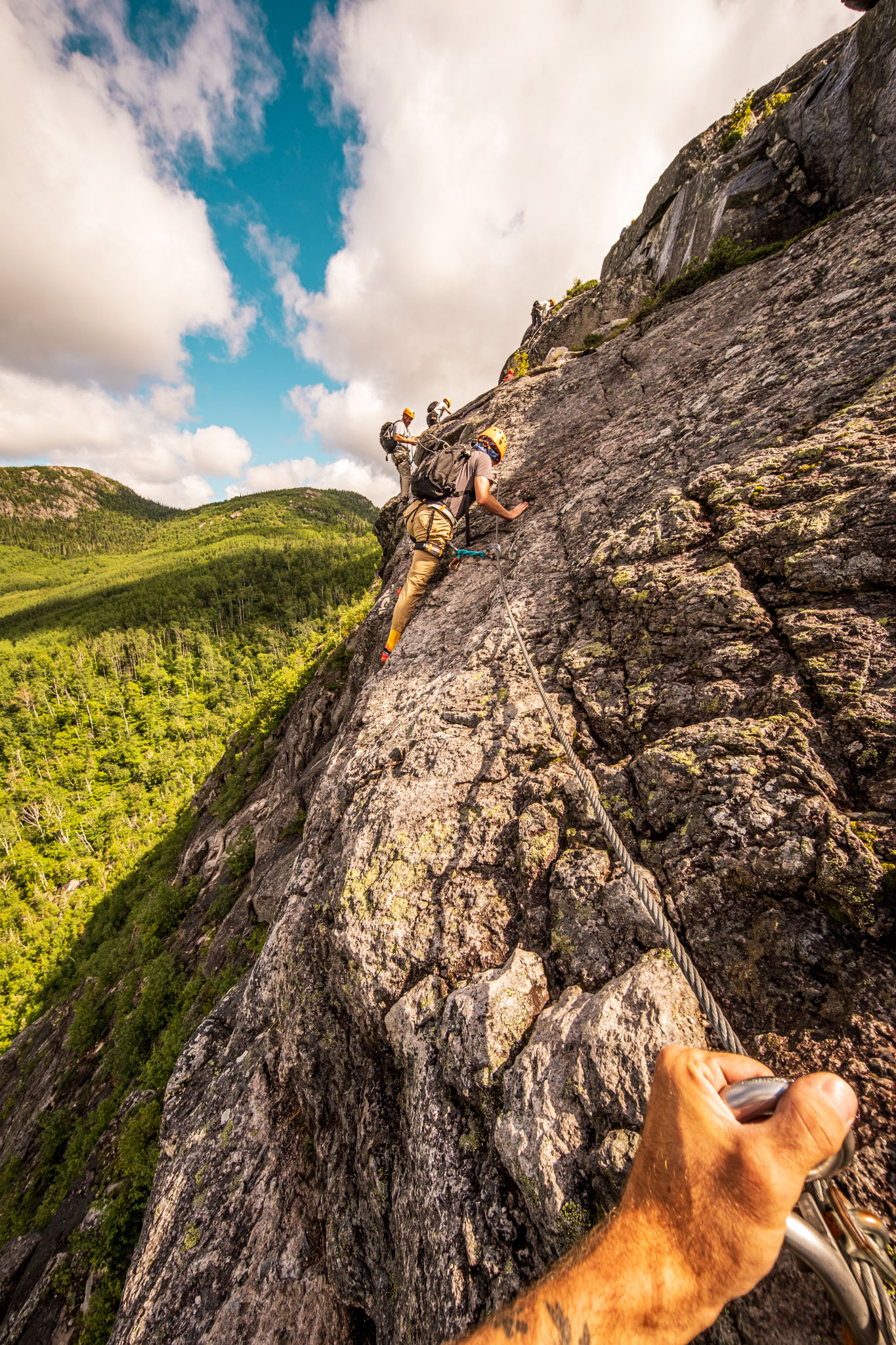 Via ferrata climbers on a rock cliff at Parc national des Grands-Jardins