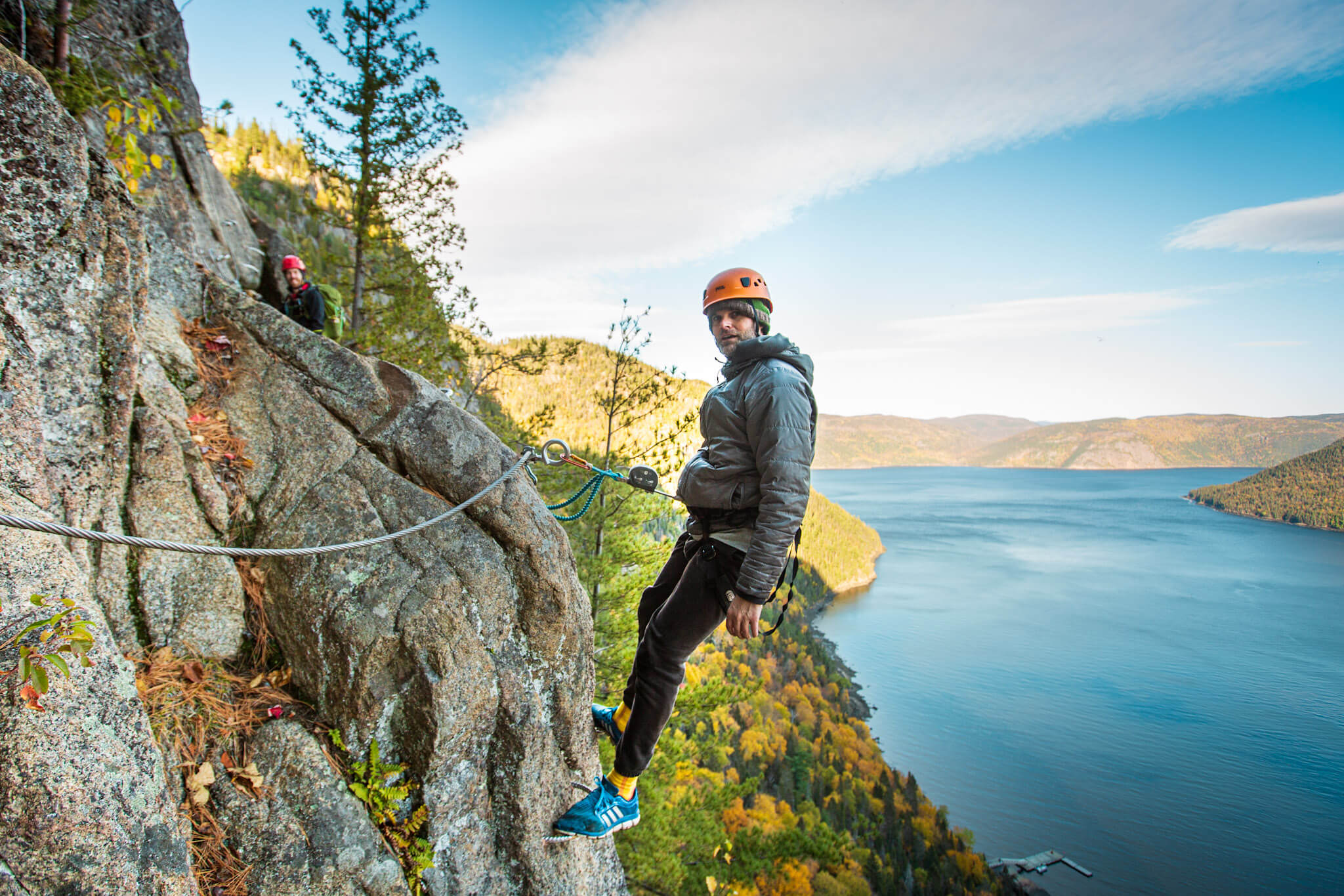 A rock climber hangs by his harness on a rock cliff in the Saguenay Fjord National Park