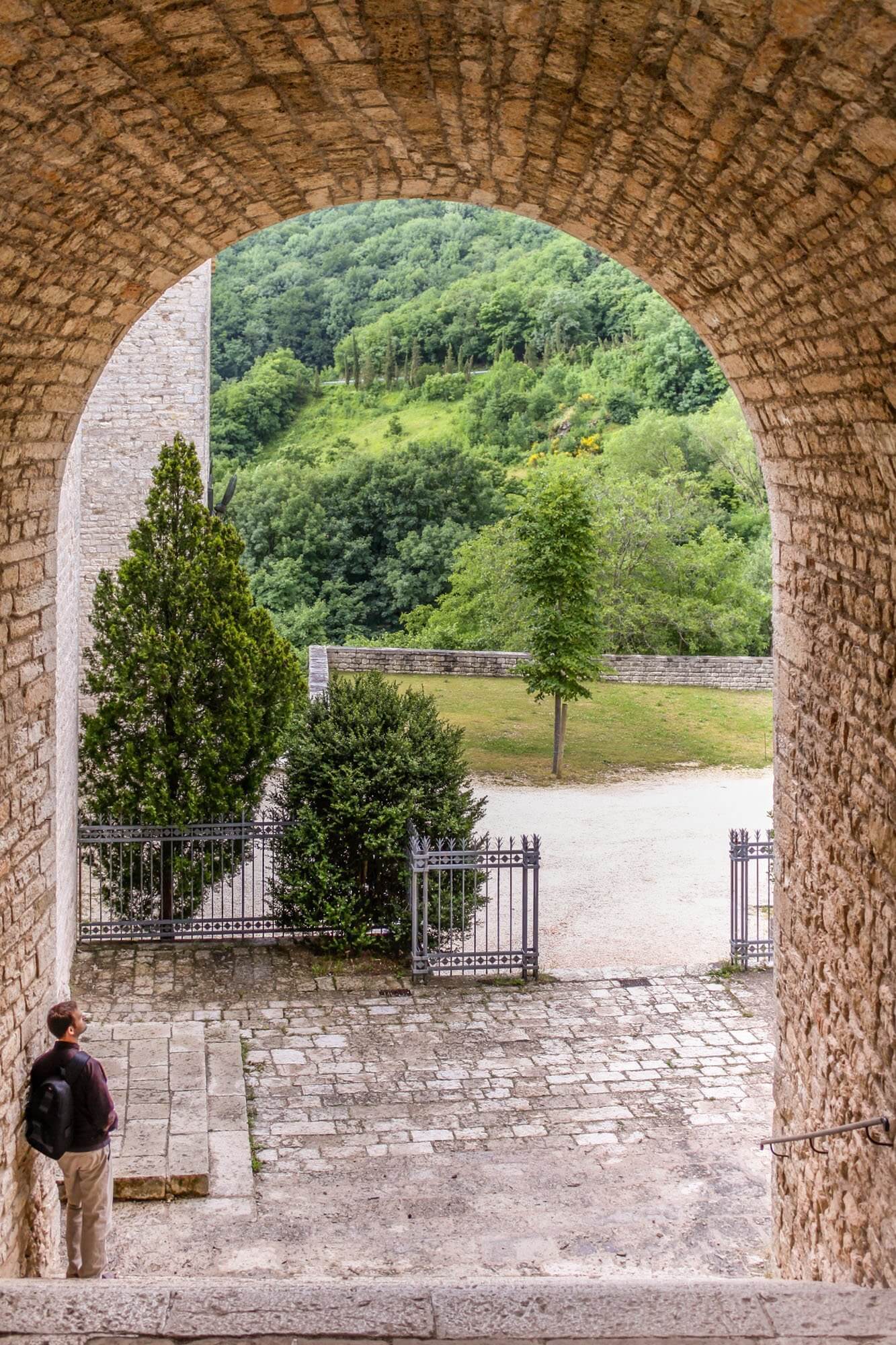 Standing under the arches of Fonte Avellana Monastery in Le Marche, Italy