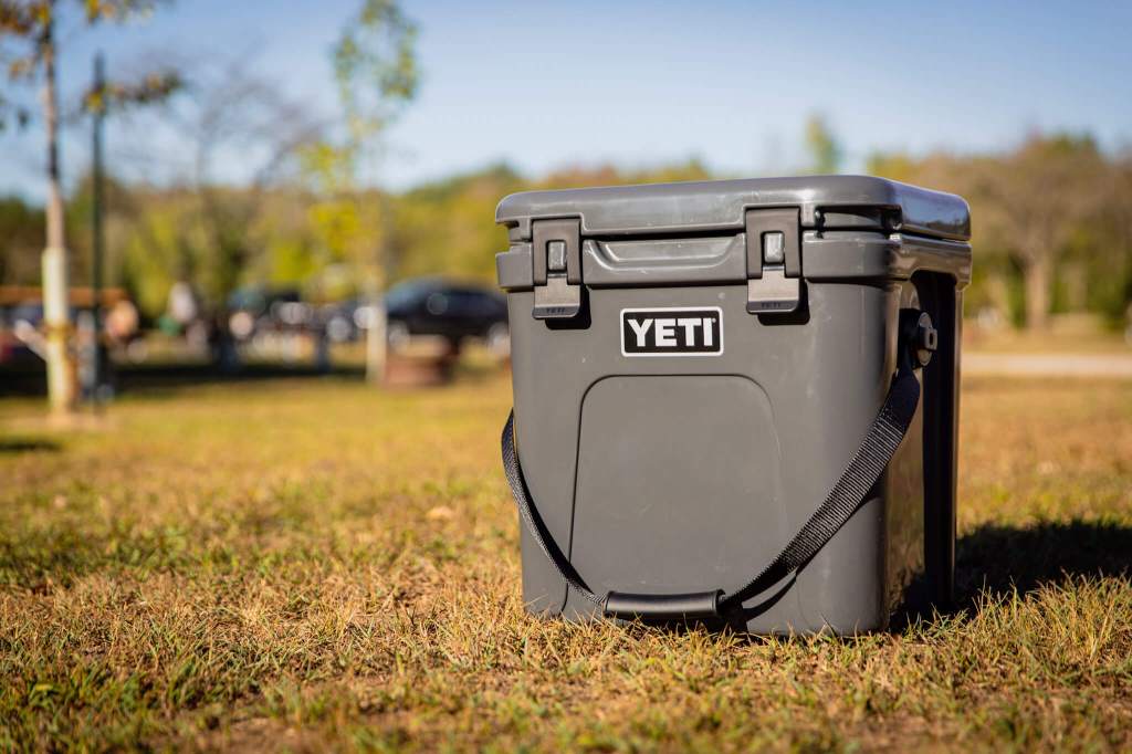The YETI Roadie 24 hard cooler on the grass in a campground