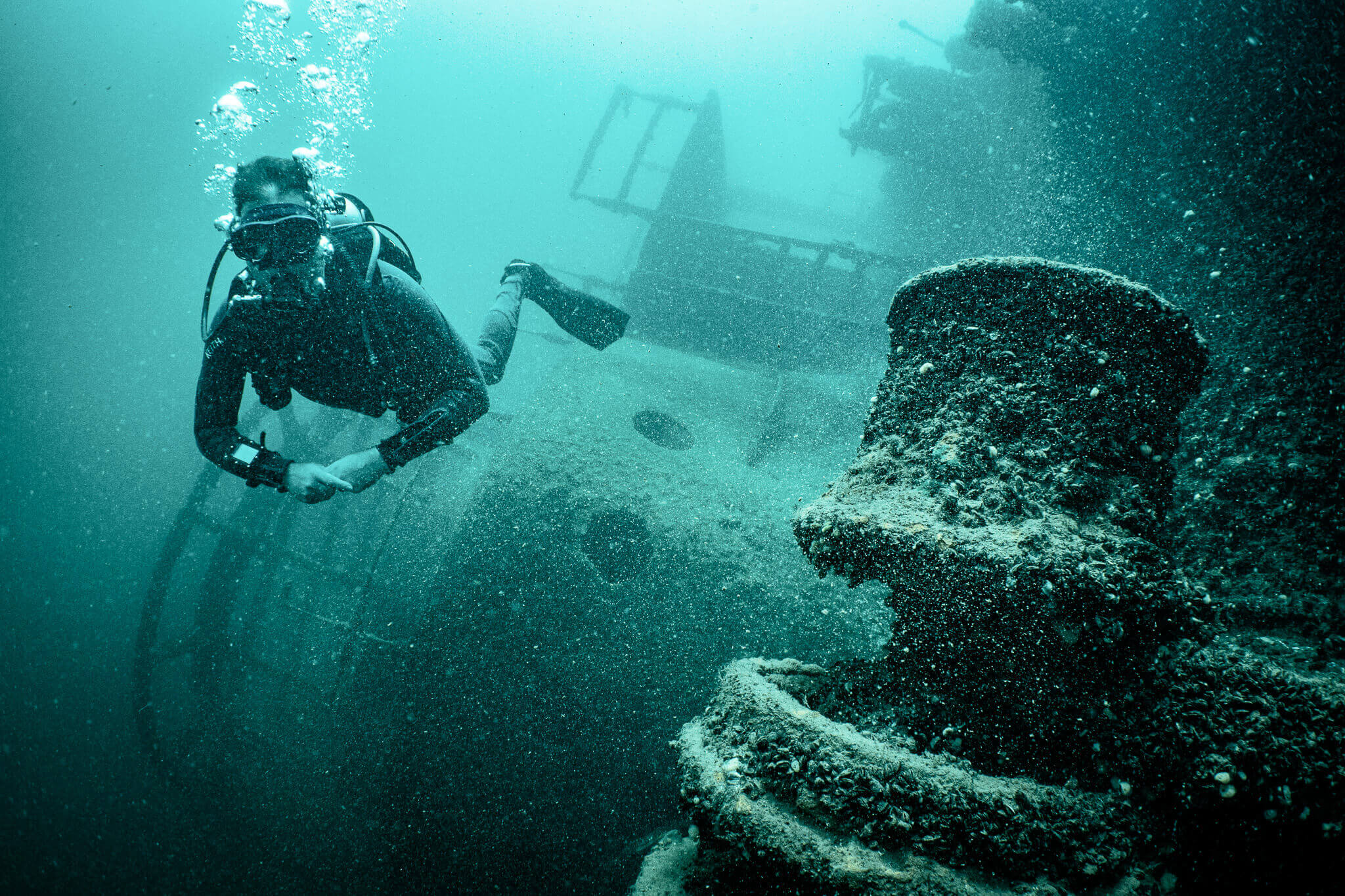 Underwater photo of a scuba diver in front of the superstructure of the Keystorm shipwreck