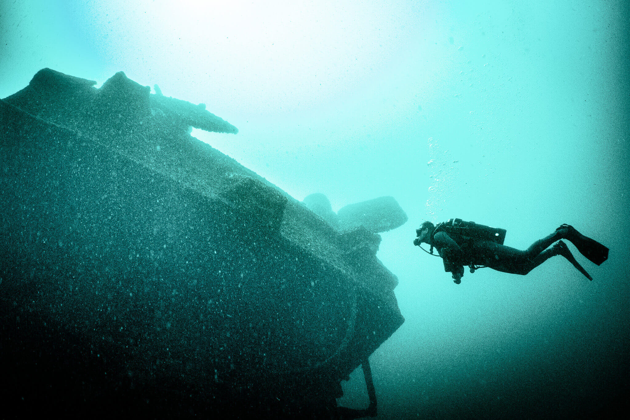 Underwater photo of a scuba diver examining the America shipwreck in the St. Lawrence River