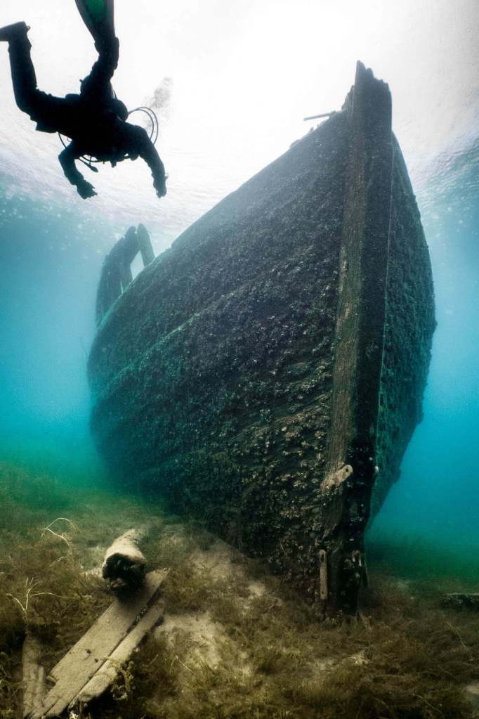 A scuba diver approaches the Sweepstakes shipwreck in Tobermory