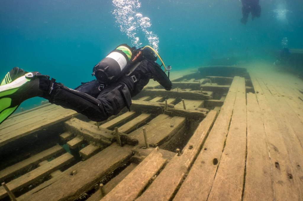 Scuba diver in a drysuit exploring the Sweepstakes shipwreck in Tobermory