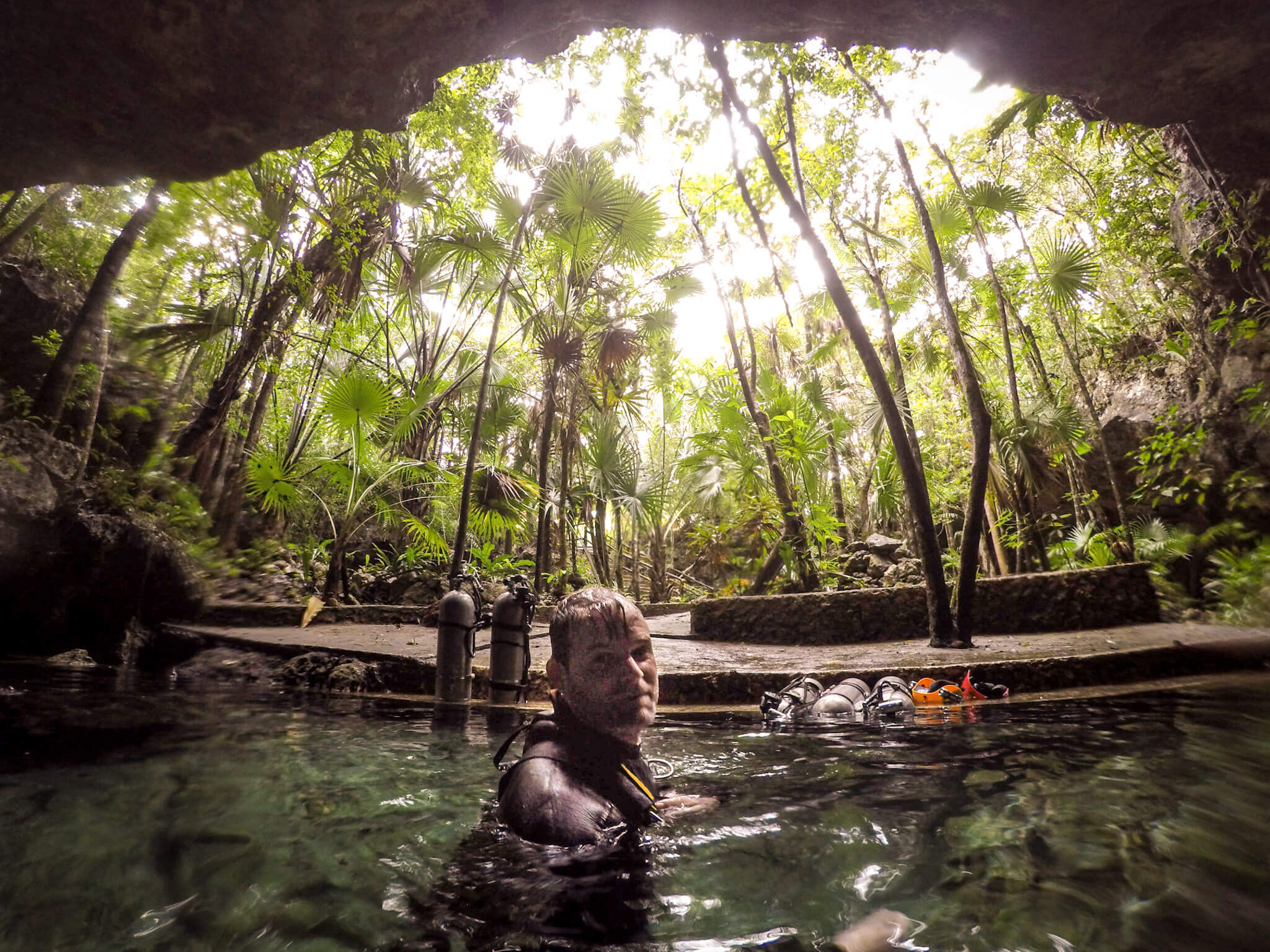 A scuba diver emerges in a cenote after a cave dive