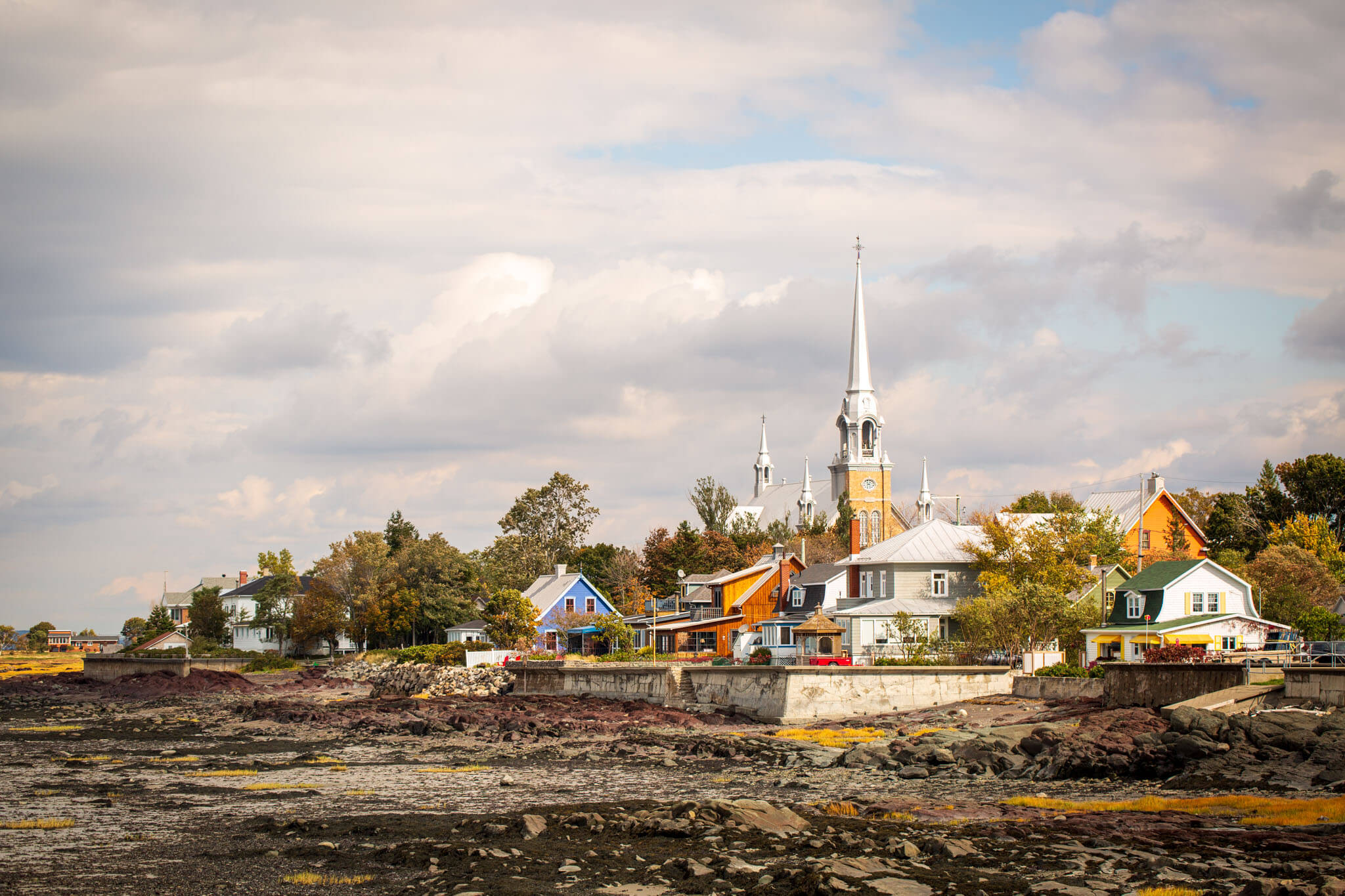 Church and steeple along the waterfront in Kamouraska, Quebec, at low tide