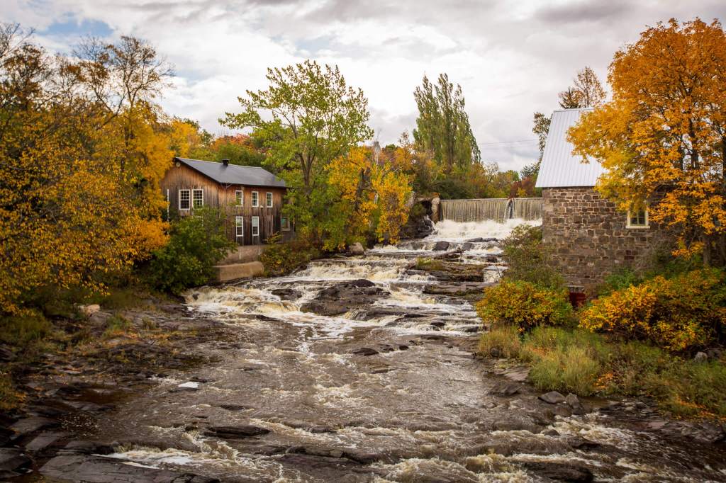 Old mill buildings along a cascading waterfall in Trois Saumons, Quebec
