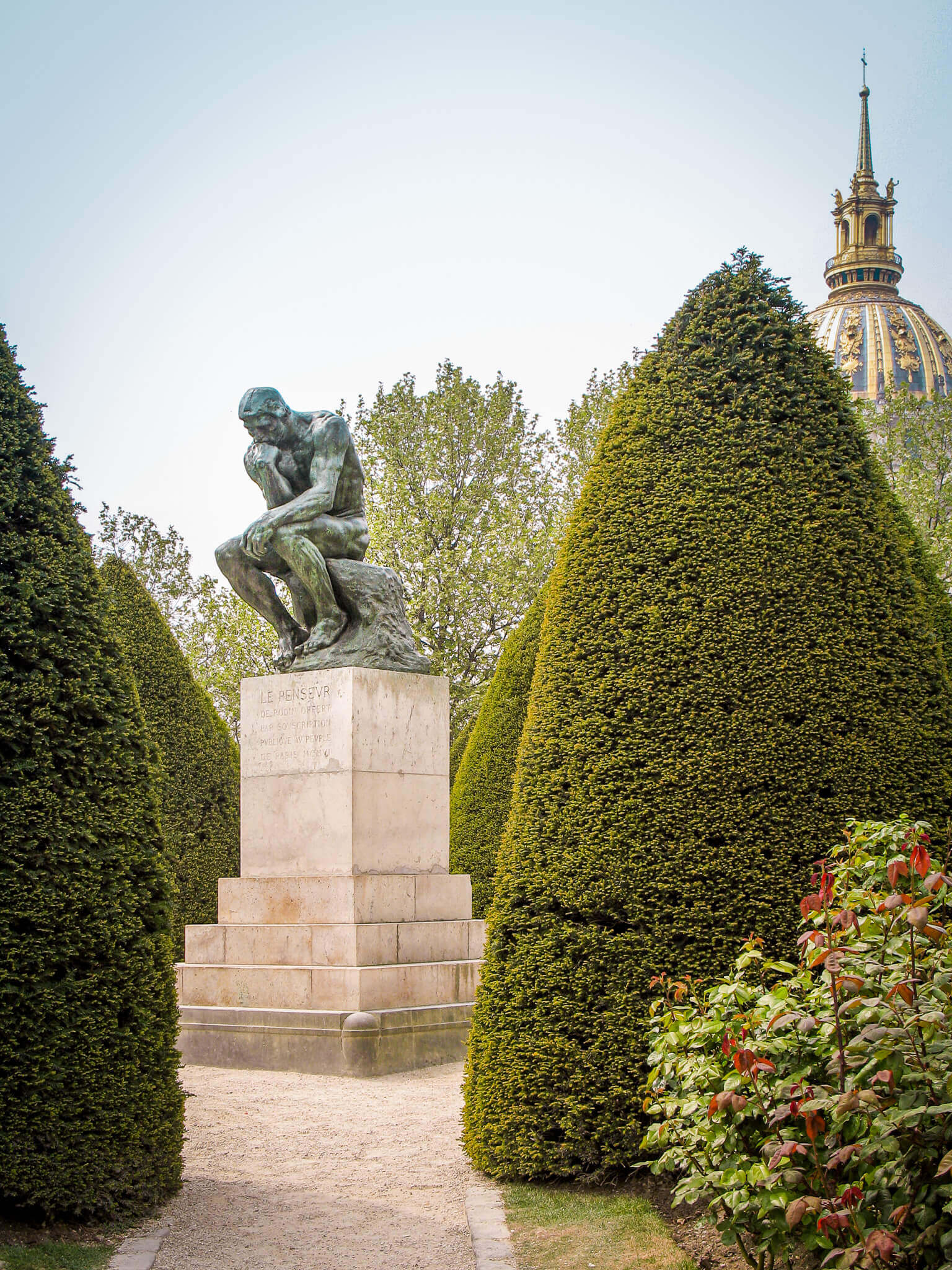 The Thinker sculpture at Musée Rodin with the dome of Les Invalides in the background