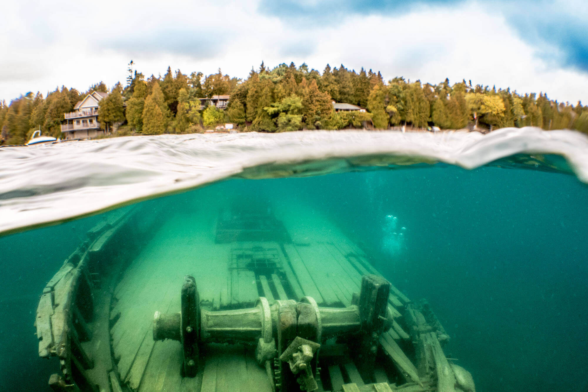 Over-under photo of the Sweepstakes shipwreck in Tobermory's Big Tub Harbour