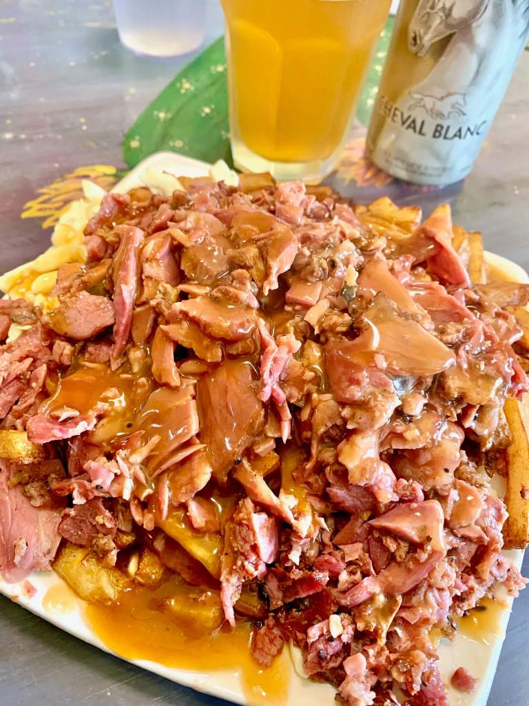 Smoked meat poutine at La Banquise in Montreal (with a local Cheval Blanc wheat beer)