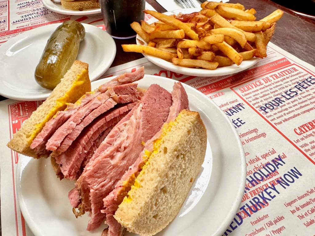 Smoked meat sandwich, pickle, fries and cherry soda at Schwartz's in Montreal